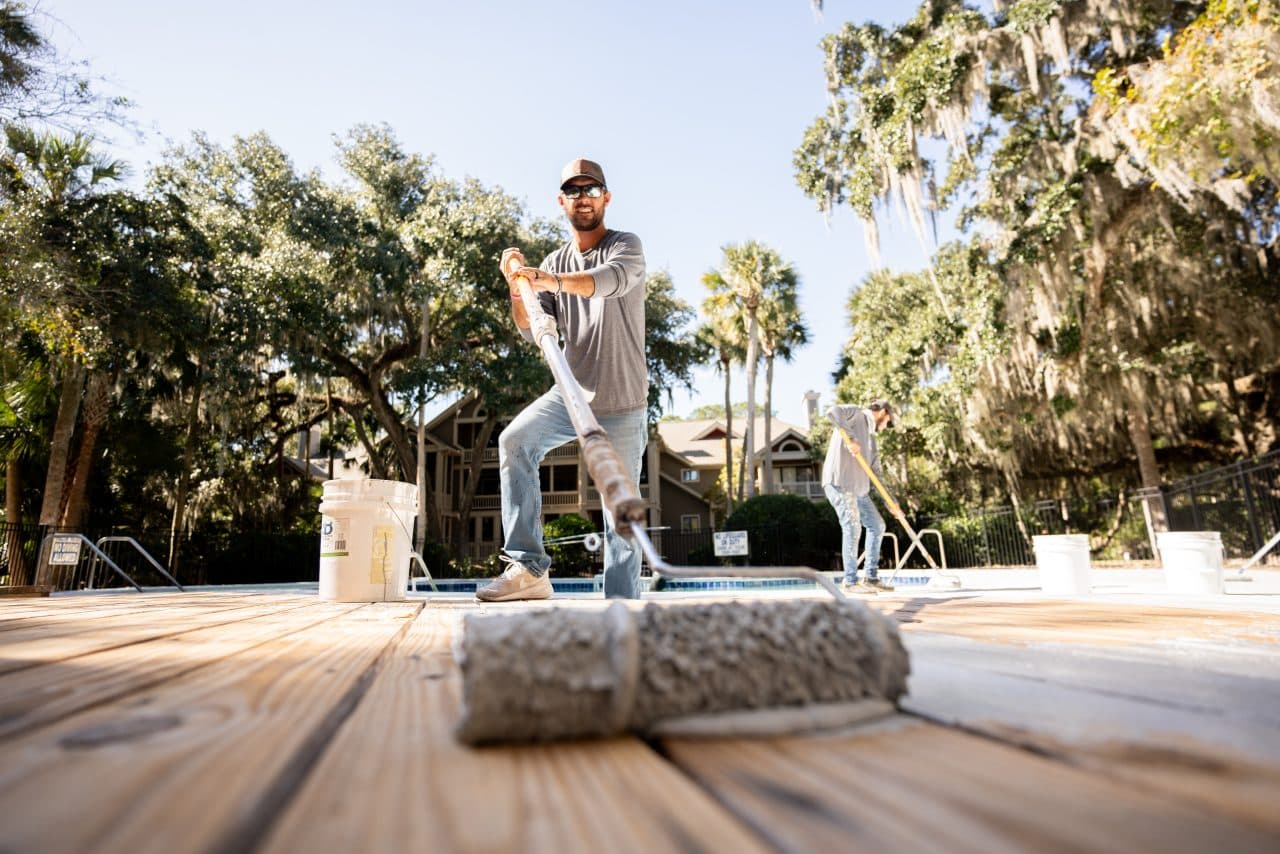 Technician applying coating on a deck